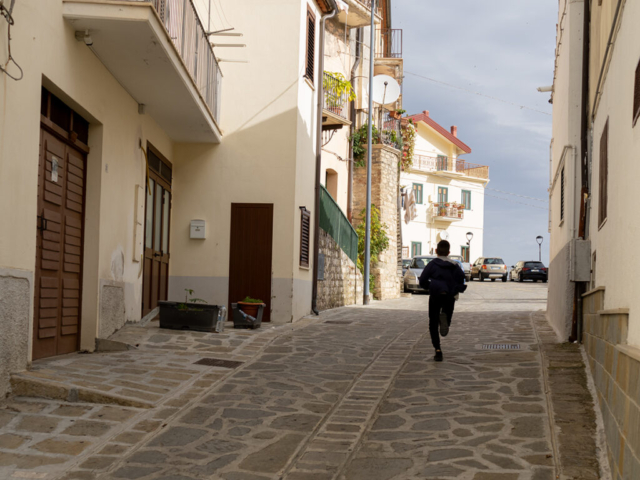bambino corre verso la scuola. Non è raro vedere giovanissimo in giro da soli per il borgo.
